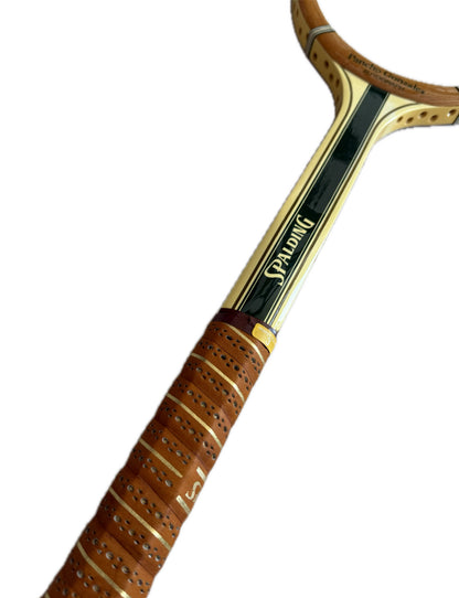 Detalle del corazón y el grip de cuero perforado de la raqueta Spalding Pancho Gonzales Autograph, con el logo Spalding en dorado