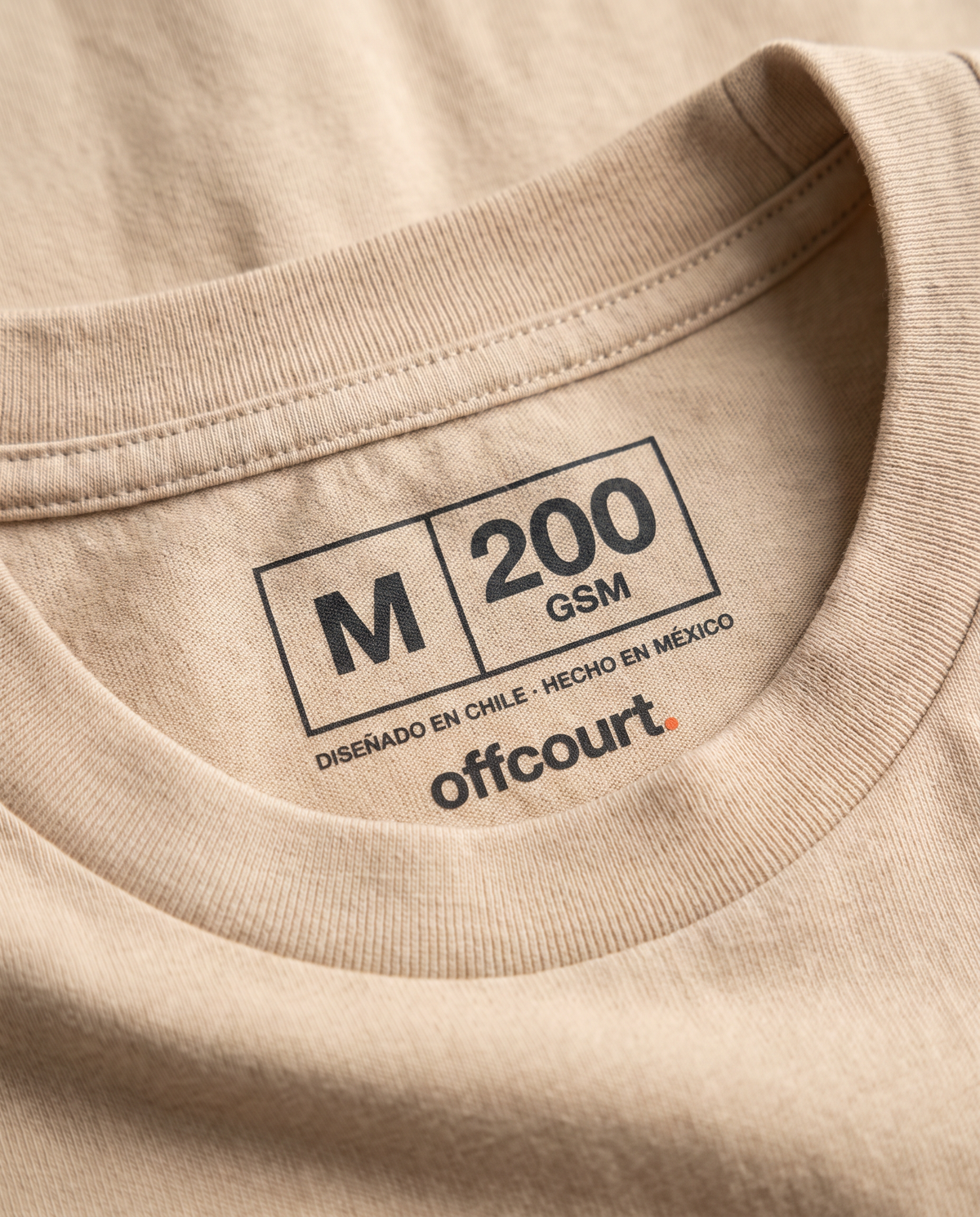 Cuello interior impreso de una polera de tenis offcourt. con talla y gramaje, sin etiqueta cosida