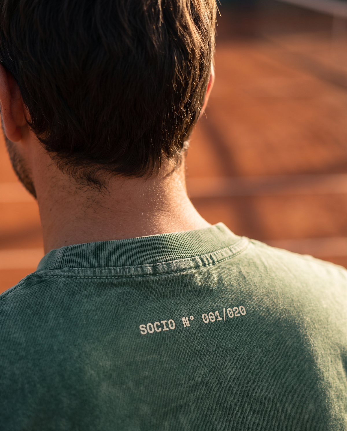 Detalle de la numeración Socio Nº 001/020 en la nuca de la polera acid wash color Bosque puesta