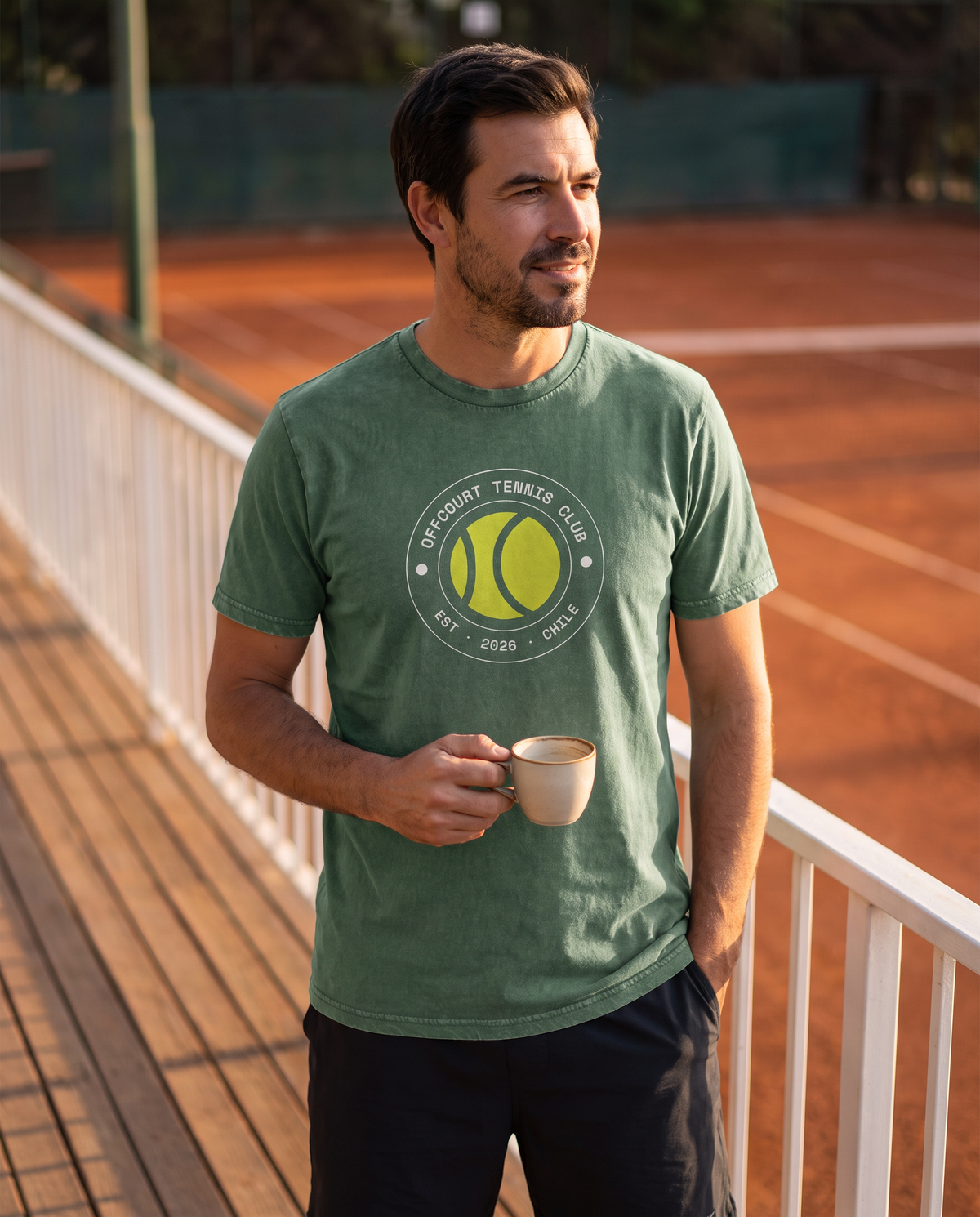 Tenista con la polera acid wash Socio Nº color Bosque y el crest OFFCOURT TENNIS CLUB en la terraza del club