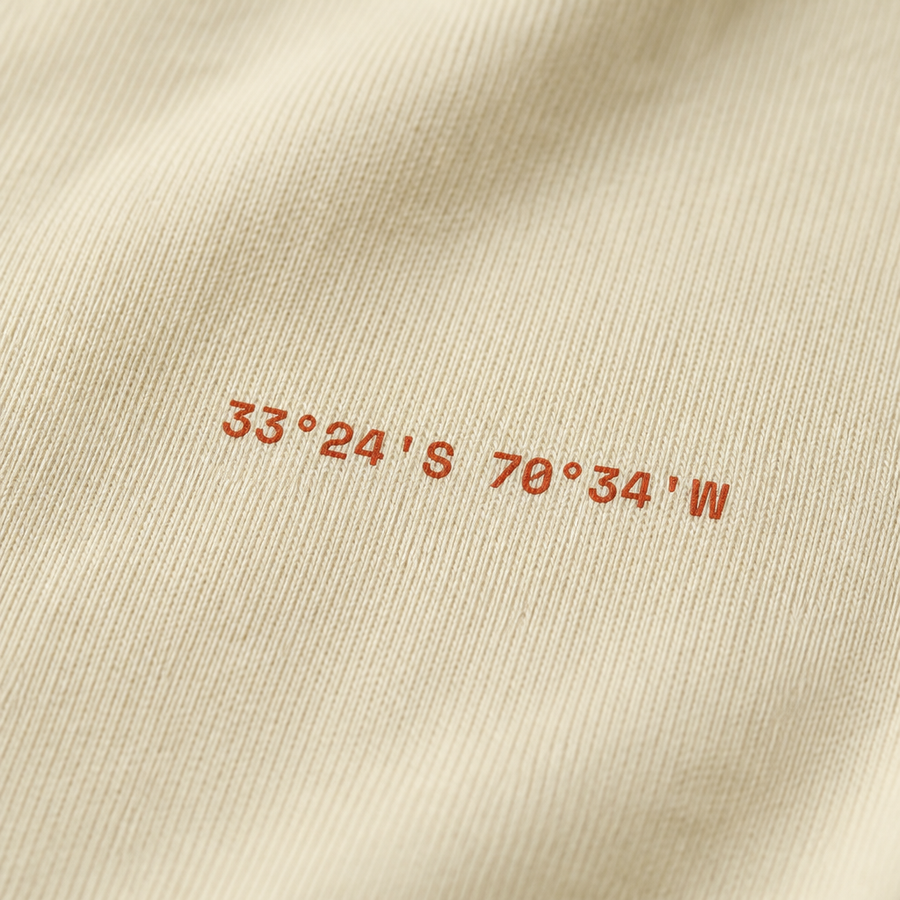Detalle de las coordenadas impresas en el pecho de la polera Club de Polvo de Ladrillo color Beige, OffCourt